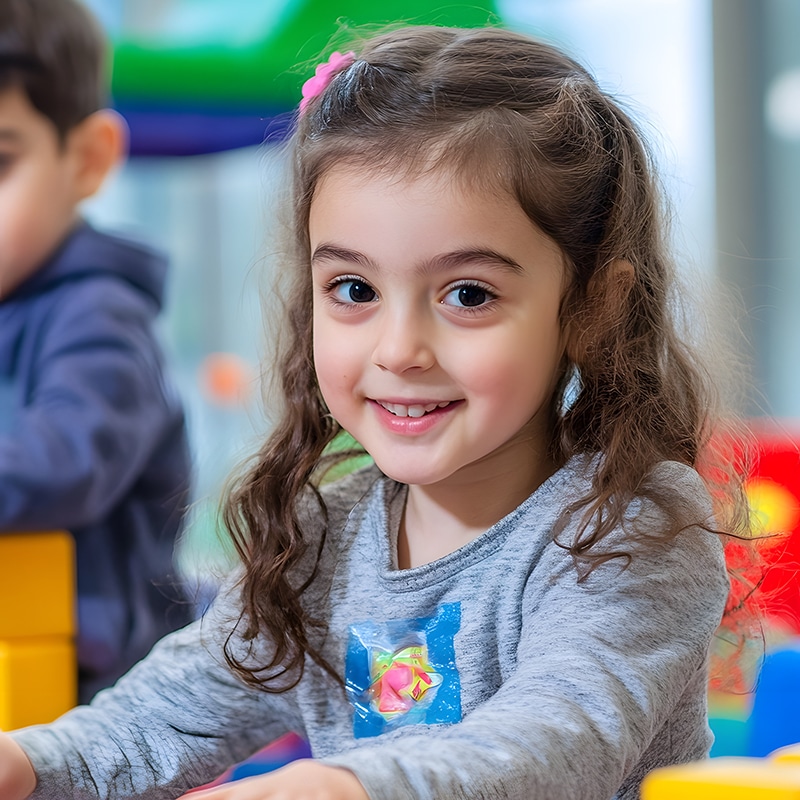 A toddler playing in a classroom.