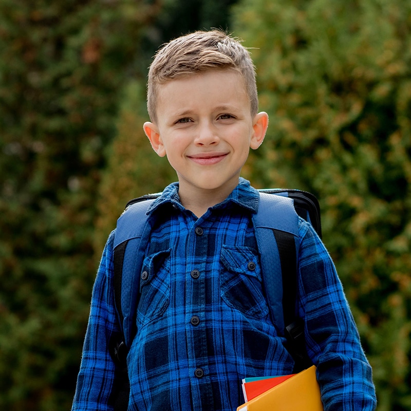 A school age boy with his books and backpack.
