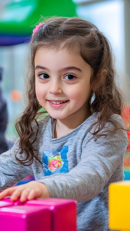 A toddler playing in a classroom.